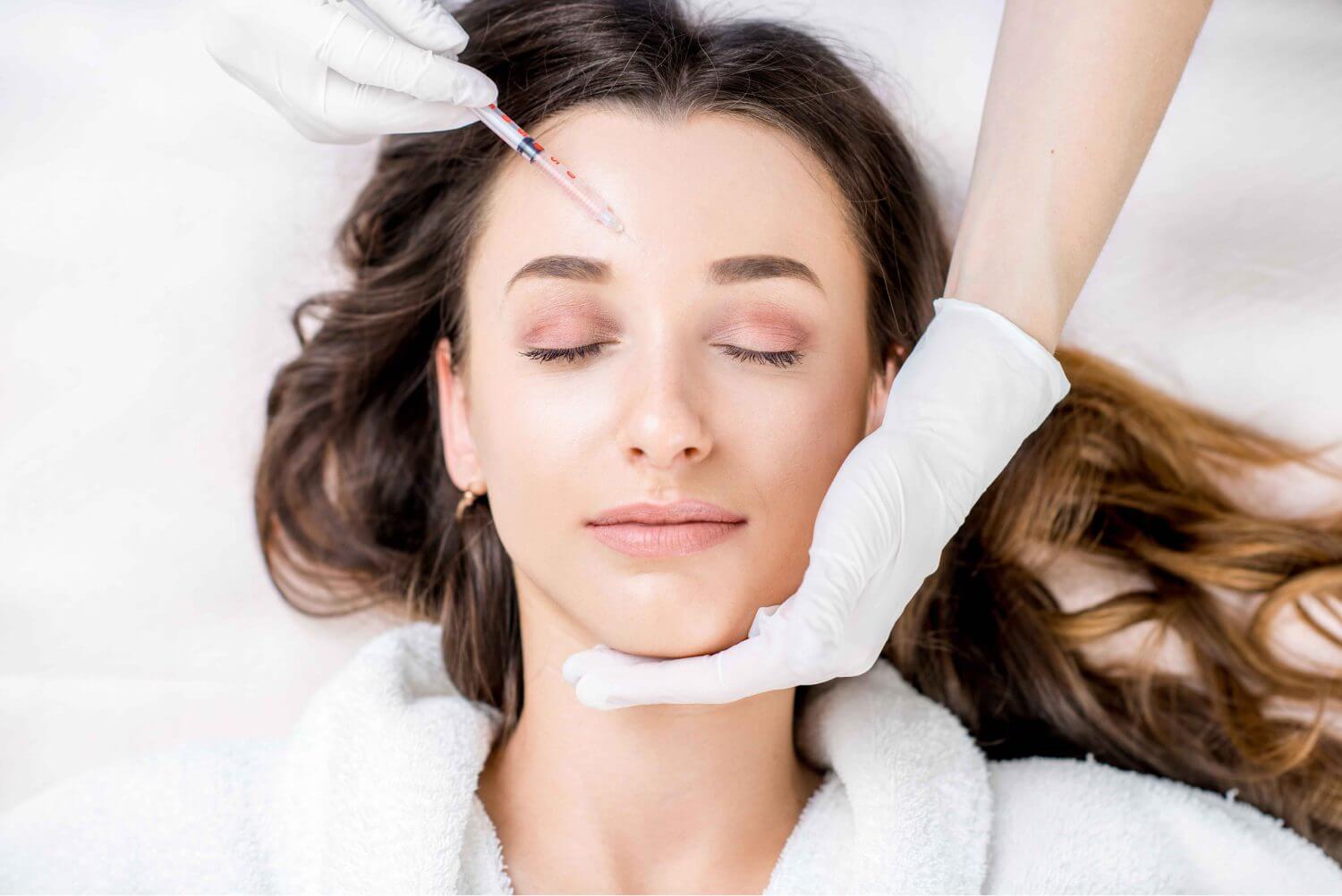 Cosmetologist holding syringe and woman's face in hands Getting Dermal Filler treatment | SavvyDerm Skin Clinic in Millville DE